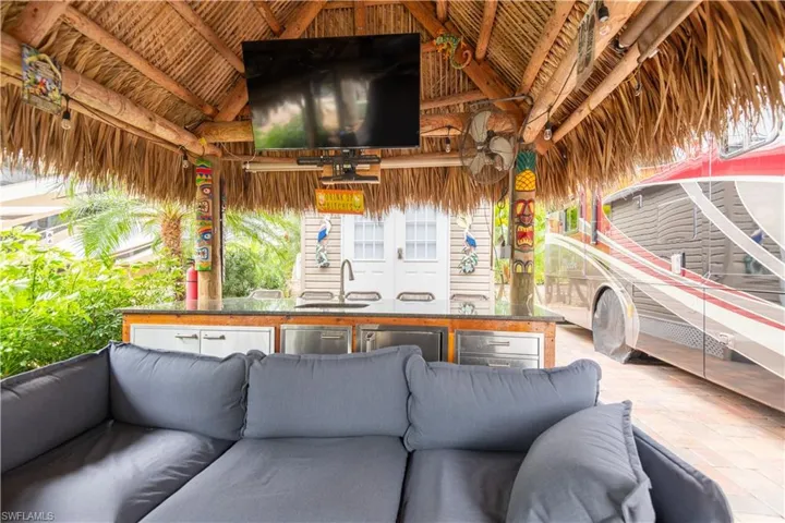 View of patio with an outdoor kitchen, ceiling fan, and an outdoor living space