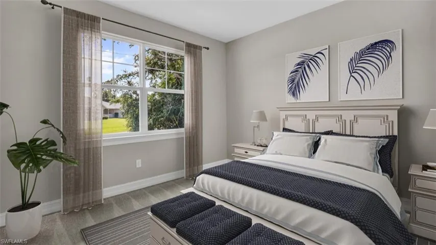 This image is virtually staged. Bedroom featuring light colored carpet and baseboards