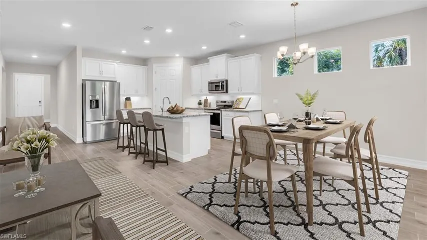 This image is virtually staged. Dining room featuring wood finish floors and a chandelier