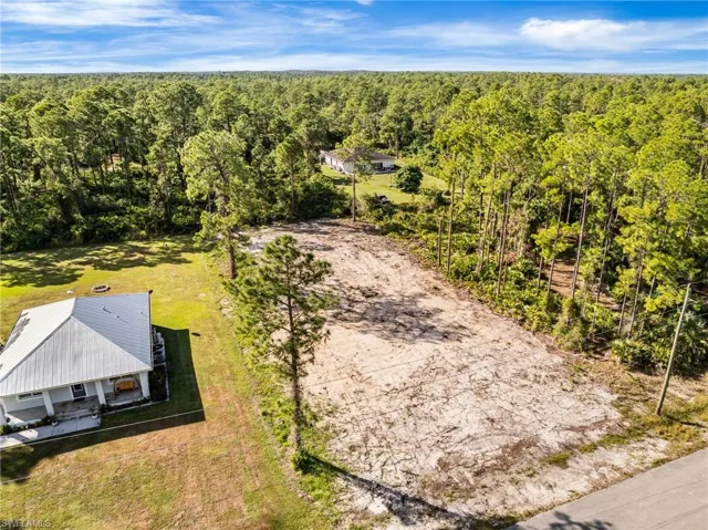 Aerial view of property and surrounding area featuring a heavily wooded area