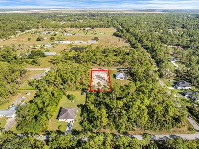 Aerial overview of property's location featuring property parcel outlined and a heavily wooded area