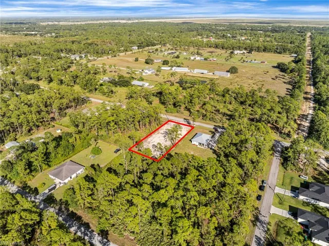 Aerial view of property and surrounding area featuring property boundaries highlighted and a heavily wooded area