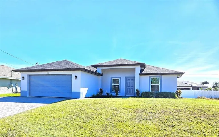 View of front of home with a garage and a front lawn
