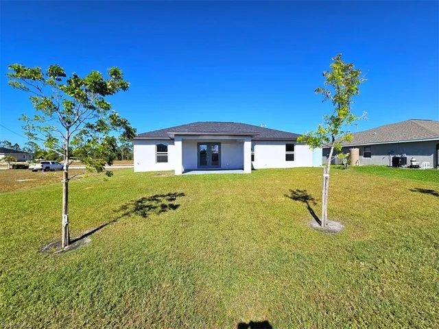 Back of property featuring a yard and french doors