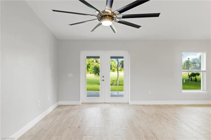 Empty room featuring french doors, light hardwood / wood-style flooring, plenty of natural light, and ceiling fan