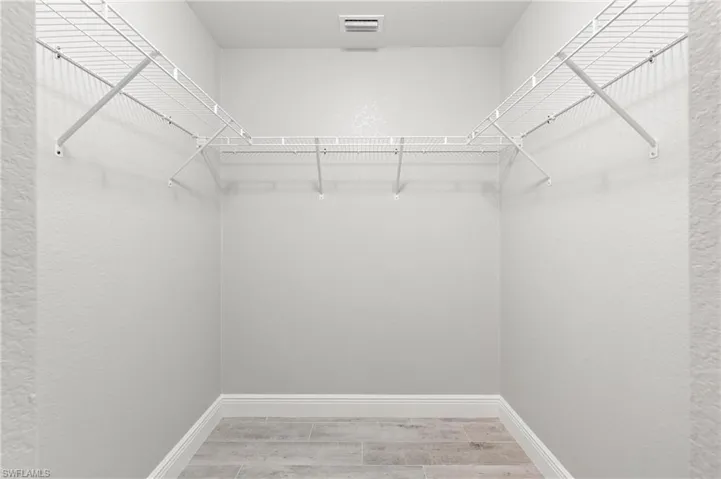 Spacious closet with hardwood / wood-style floors