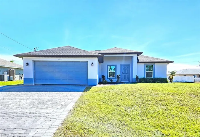 View of front of property featuring a garage, central air condition unit, and a front yard