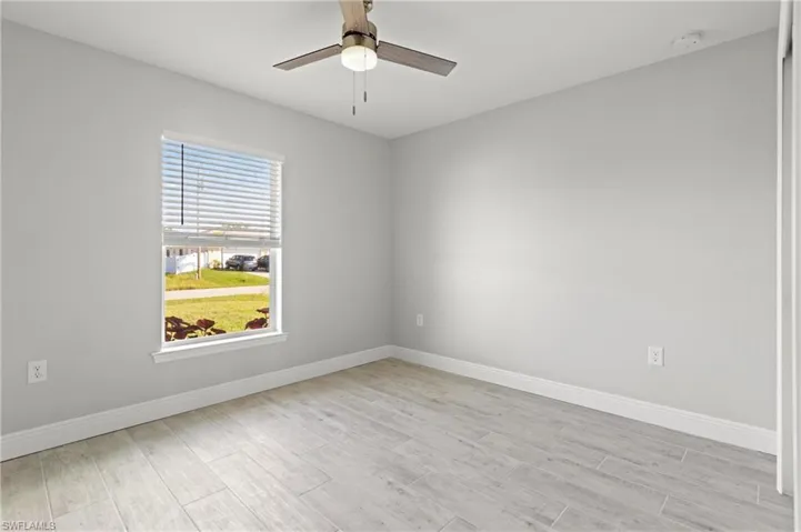 Unfurnished room with ceiling fan and light hardwood / wood-style floors