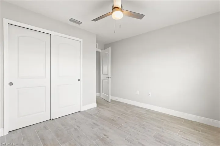Unfurnished bedroom featuring ceiling fan, a closet, and light hardwood / wood-style flooring