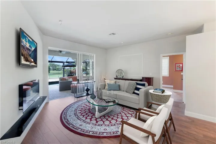 Living area featuring baseboards, wood finished floors, and a ceiling fan