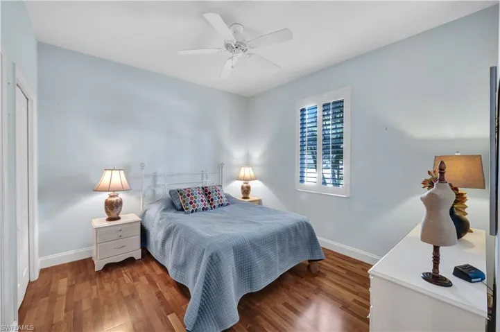 Bedroom with wood finished floors, a ceiling fan, and baseboards