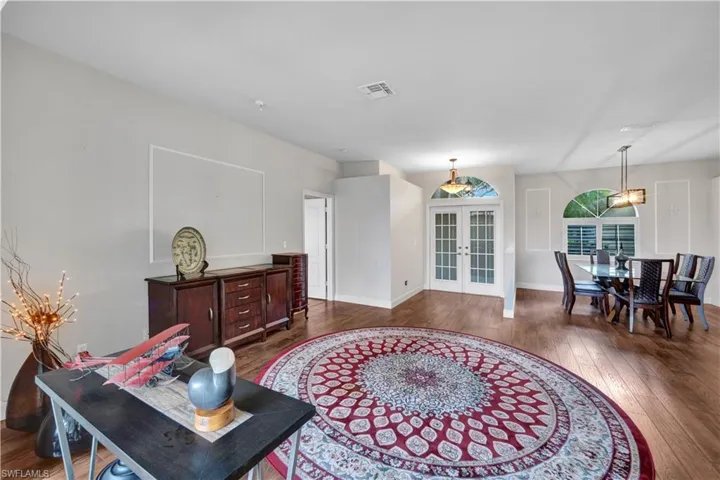 Living room featuring french doors, visible vents, dark wood-style floors, and baseboards