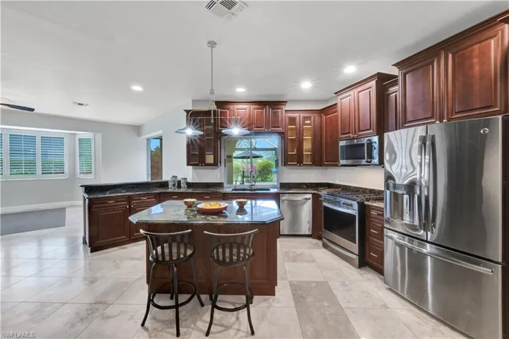 Kitchen with a sink, a healthy amount of sunlight, visible vents, a peninsula, and appliances with stainless steel finishes