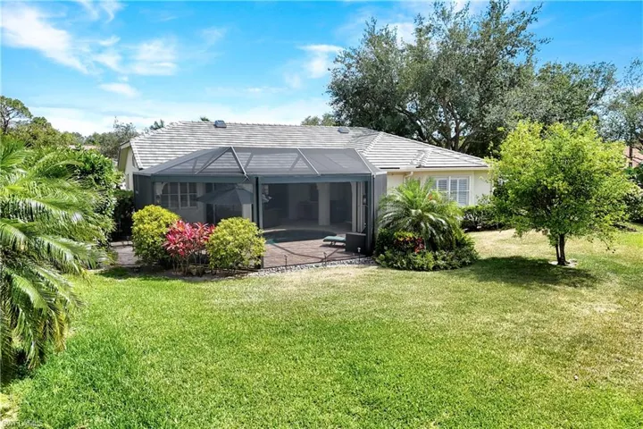 Back of house featuring a lawn, a lanai, and a patio
