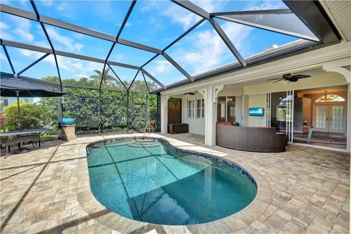 Outdoor pool with a lanai, a patio area, french doors, and ceiling fan