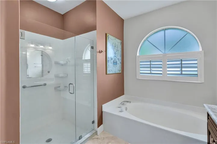 Bathroom with a garden tub, a stall shower, and vanity