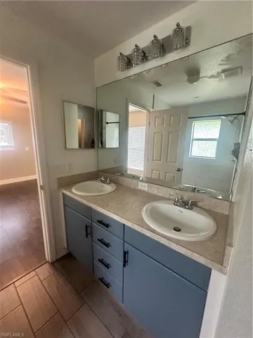 Bathroom with double vanity and wood finish floors