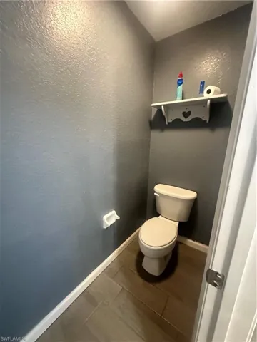 Bathroom featuring wood finish floors and a textured wall