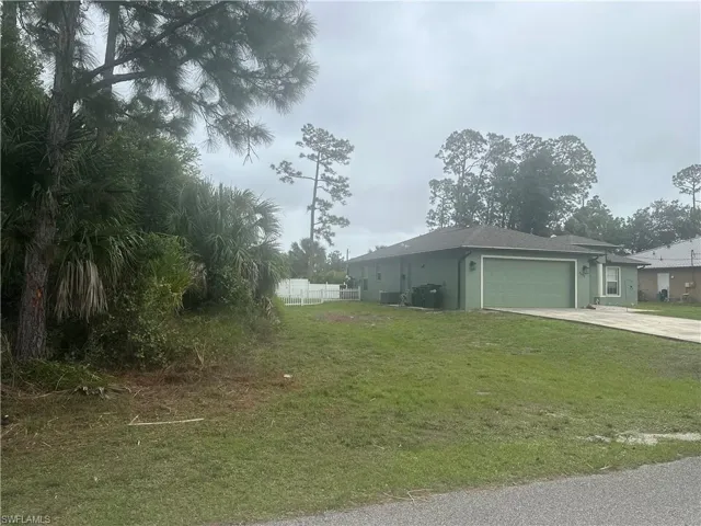 View of property exterior with an attached garage, concrete driveway, and stucco siding