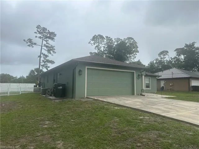 View of home's exterior with an attached garage, stucco siding, and driveway