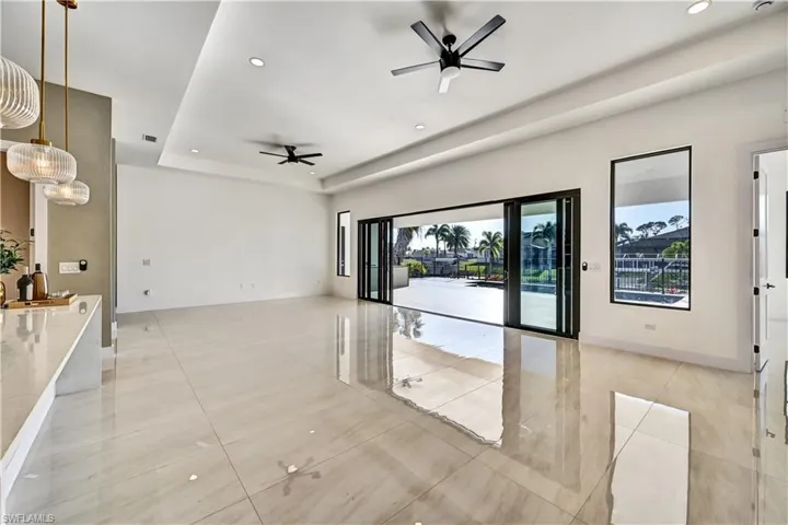 Unfurnished room with recessed lighting, a ceiling fan, a raised ceiling, and light tile patterned floors