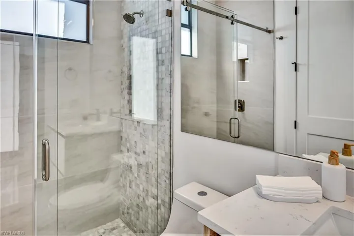 Full bath featuring a shower stall and vanity