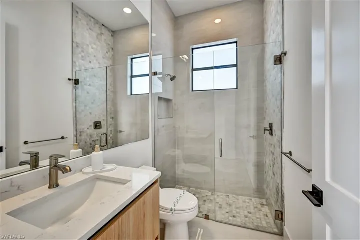 Full bathroom featuring vanity, a shower stall, and recessed lighting