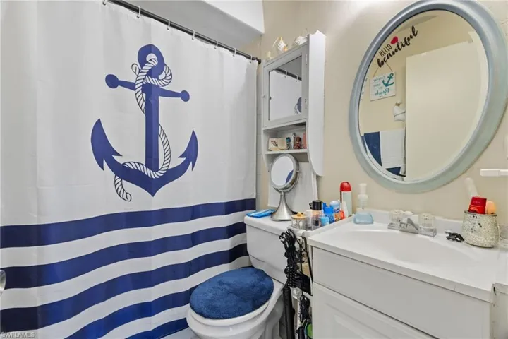 Tub/Shower combination and white cabinetry in the bathroom.