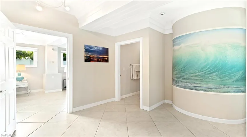 Corridor featuring crown molding and light tile patterned flooring