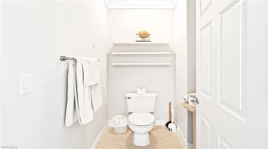 Bathroom with toilet and light tile patterned floors