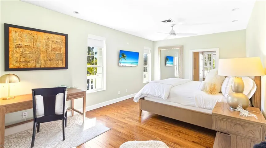 Bedroom with light wood-style floors, multiple windows, and ceiling fan