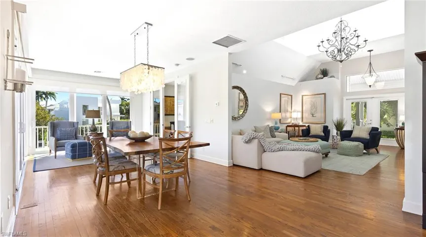 Dining area featuring suspended lighting, french doors, dark wood-style flooring, and vaulted ceiling
