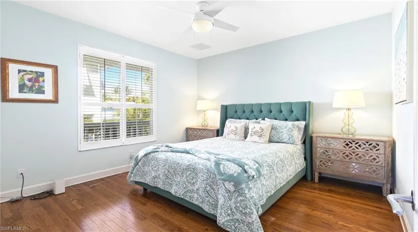Bedroom with dark wood-style flooring and ceiling fan