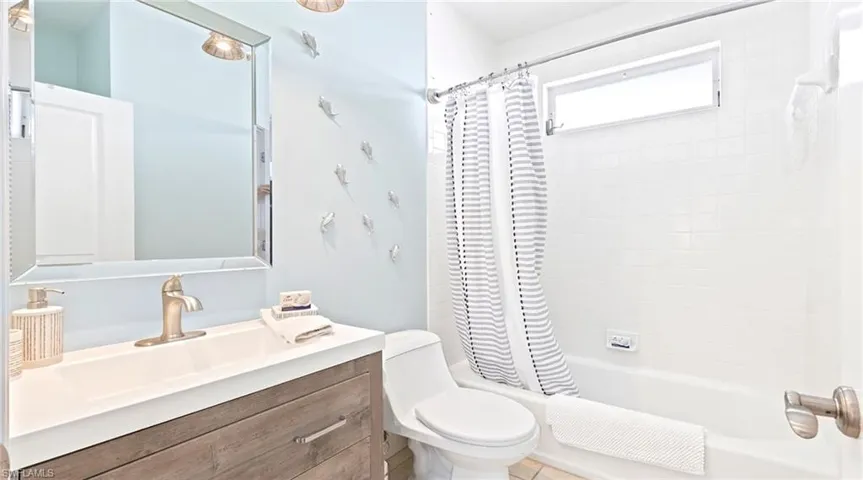 Bathroom with vanity and shower / bath combination with curtain