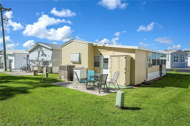 Rear view of house with a patio area and a yard