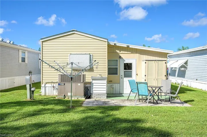 Rear view of house with a patio area and a yard