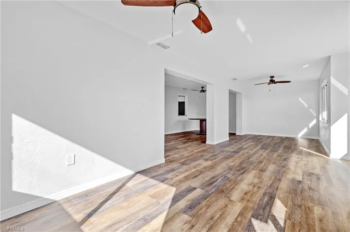 Unfurnished living room with light wood-style flooring and baseboards