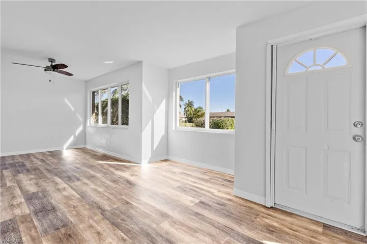 Foyer entrance with light wood-style floors and ceiling fan
