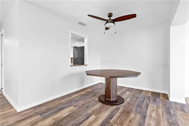 Unfurnished dining area with dark wood finished floors and ceiling fan