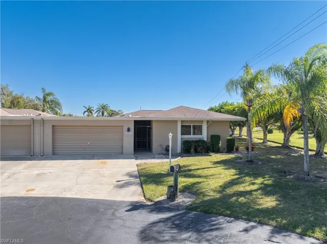 Ranch-style home with stucco siding, a front yard, concrete driveway, and an attached garage