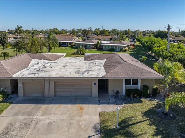 Ranch-style house with a front yard, stucco siding, concrete driveway, and a residential view