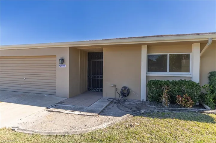 View of front of house featuring stucco siding, concrete driveway, a garage, and a front yard