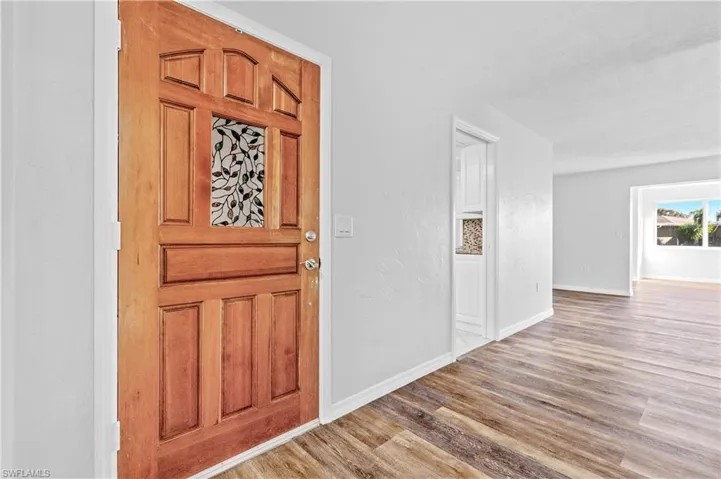 Foyer entrance with wood finished floors and baseboards