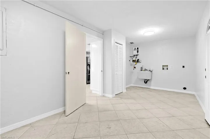 Laundry room featuring hookup for a washing machine, electric dryer hookup, and light tile patterned floors