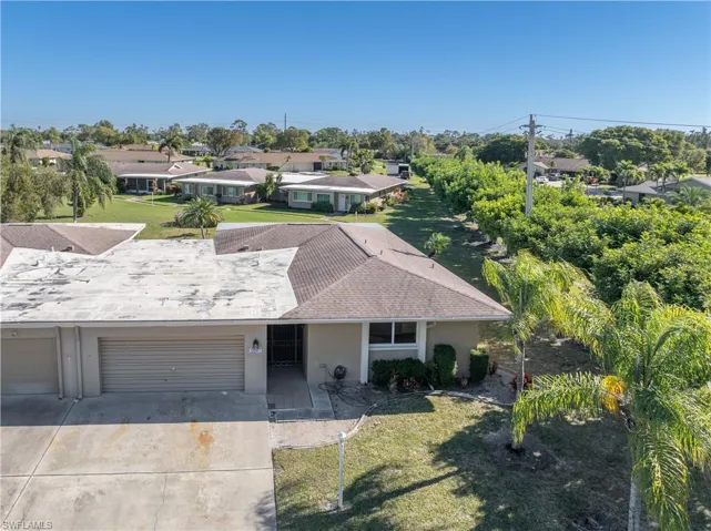Single story home with a front yard, stucco siding, concrete driveway, a residential view, and a garage