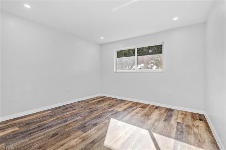 Unfurnished room with wood finished floors and recessed lighting