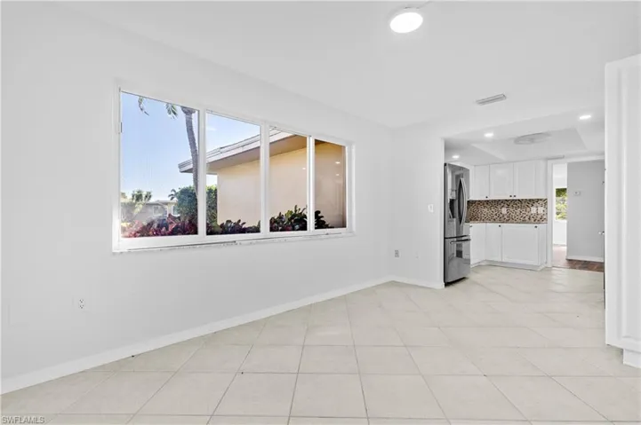 Unfurnished living room featuring light tile patterned floors, recessed lighting, and a tray ceiling