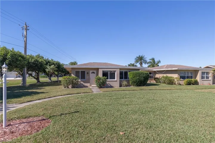 Ranch-style house with stucco siding and a front yard