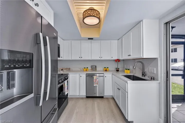 Kitchen with appliances with stainless steel finishes, white cabinetry, and light wood-style floors