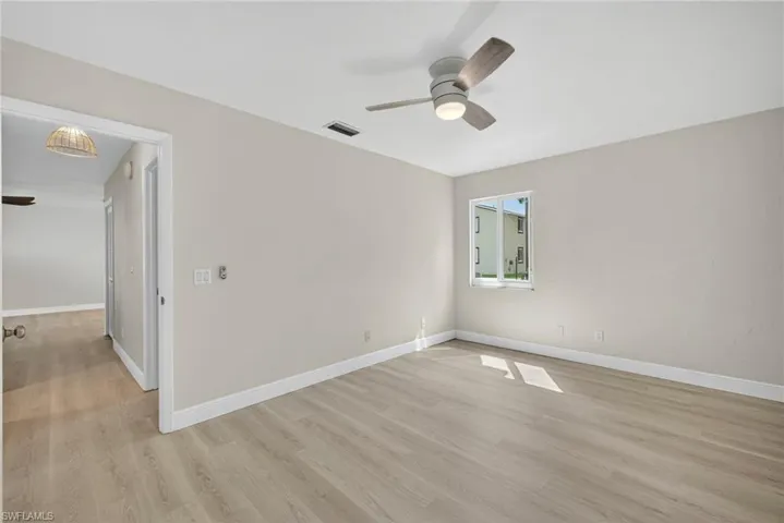 Empty room with a ceiling fan and light wood-type flooring